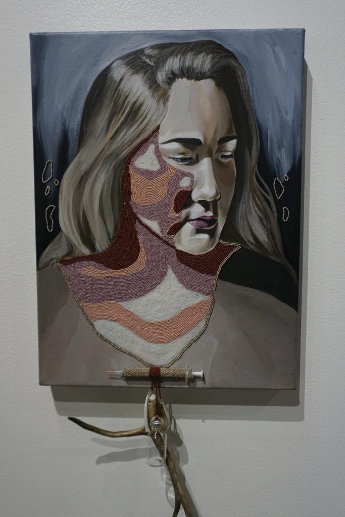 Melissa Shaginoffs Kaggkaggos tsen zuul (Swan Wing Bone / Drinking Tube) is a portrait of her youngest sister that includes a swan wing bone necklace with an insulin bottle and beaded syringe. Ahtna young women were given necklaces at the time of their first menstruation. Of her work, Shaginoff writes: At puberty I was diagnosed with type-one diabetes, and autoimmune disease that like colonization attacks the body with reasons unknown and foreign. In place of a puberty necklace I was given a syringe and insulin bottles, tools of a colonized environment. But I see my experience as a story of decolonization. (Photo by Michael Armstrong/Homer News)