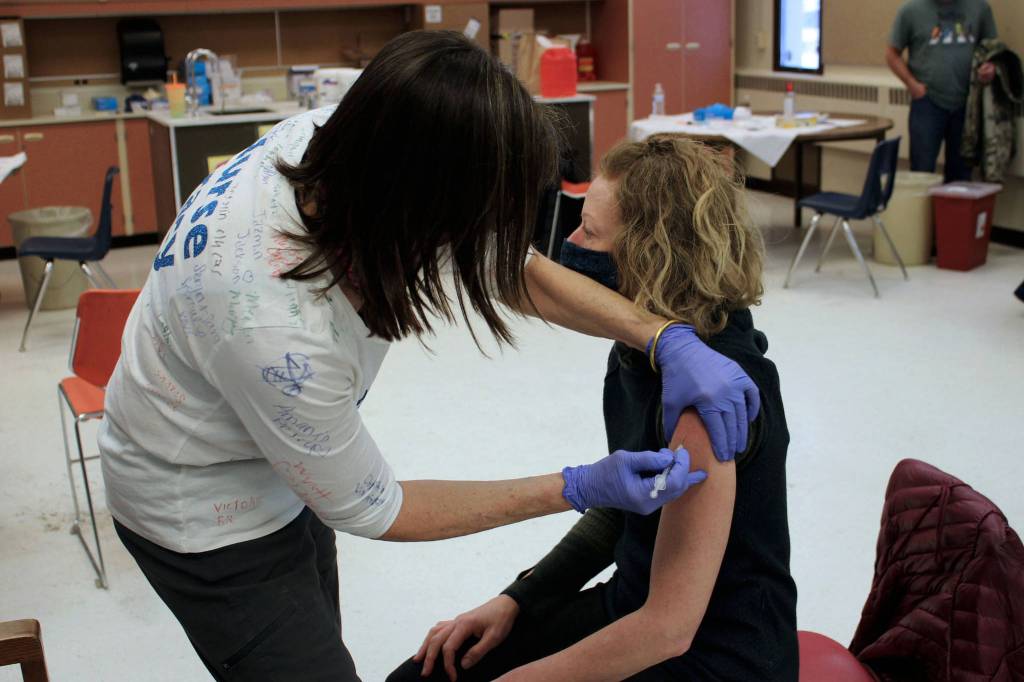 Tracy Silta (left) administers a dose of a COVID-19 vaccine to Melissa Linton during a vaccine clinic at Soldotna Prep School on Friday, Feb. 26, 2021, in Soldotna, Alaska. (Ashlyn OHara/Peninsula Clarion)
