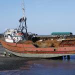 Crews work on a boat on Monday, April 5, 2021, at the large-vessel haul out beach on the Homer Spit near the Pier 1 Theatre in Homer, Alaska. In the off season boats are hauled onshore for repair at the beach near the Nick Dudiak Fishing Lagoon. (Photo by Michael Armstrong/Homer News)