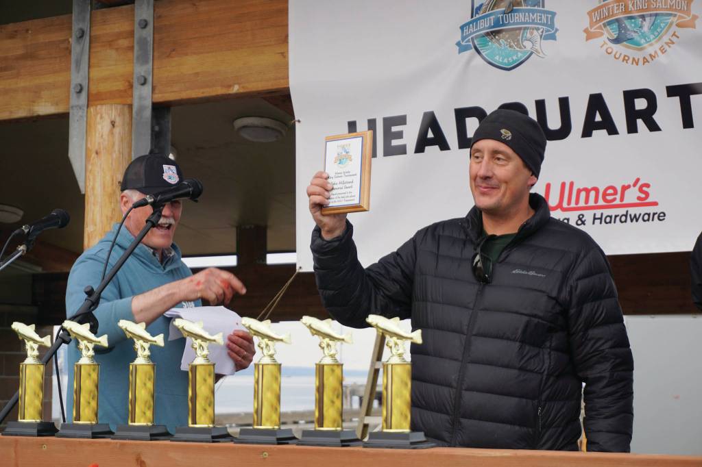 Capt. Jay Marley of the Fly Dough accepts the captains award for the boat that had the first-place fish in the 2021 Homer Winter King Salmon Tournament. Marleys son, Andrew, caught the 25.62-pound winner. Homer Chamber of Commerce and Visitor Center Executive Director Brad Johnson, left, presented the plaque on Saturday, April 17, 2021, on the Homer Spit in Homer, Alaska. (Photo by Michael Armstrong/Homer News)
