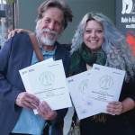 Homer News editor Michael Armstrong, left, and fomer reporter Megan Pacer, right, hold Alaska Press Club awards the Homer News received at the Alaska Press Club Awards banquet on April 27, 2019, in Anchorage, Alaska. (Photo by Brian Mazurek/Peninsula Clarion)