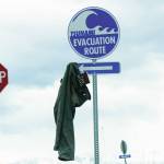 A pair of pants with a copy of Cormac McCarthys novel, The Road, hangs from a tsunami evacuation route sign on Saturday, May 8, 2021, at Mariner Park on the Homer Spit in Homer, Alaska. (Photo by Michael Armstrong/Homer News)