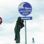 A pair of pants with a copy of Cormac McCarthy's novel, "The Road," hangs from a tsunami evacuation route sign on Saturday, May 8, 2021, at Mariner Park on the Homer Spit in Homer, Alaska. (Photo by Michael Armstrong/Homer News)