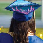 Photo by Sarah Knapp/Homer News 
A Homer High School graduate dons her graduation cap featuring Alaska scenery, including fireweed and the bay.