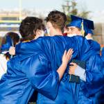 Three Homer High seniors embrace after graduating on May 18. (Photo by Sarah Knapp/Homer News)