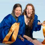 Two girls ride on top of their car during the graduation parade through Homer. (Photo by Sarah Knapp/Homer News)
