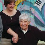 Jennifer Norton, left, holds Mary Eppersons hand as she visits the writings on her Etude Studio for Mary Epperson Day on June 6, 2014, in Homer, Alaska. (Photo by Michael Armstrong/Homer News file photo)