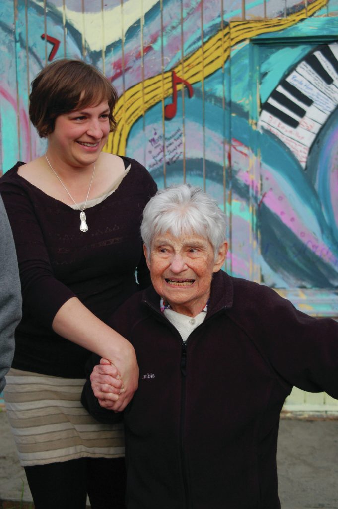 Jennifer Norton, left, holds Mary Eppersons hand as she visits the writings on her Etude Studio for Mary Epperson Day on June 6, 2014, in Homer, Alaska. (Photo by Michael Armstrong/Homer News file photo)