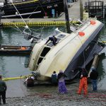 Workers respond to a fishing boat, the F/V Redoubt, that ran aground on the wooden grid on Wednesday, June 2, 2021, in the Homer Harbor in Homer, Alaska. The boat heeled over as the tide went out. (Photo by Michael Armstrong/Homer News)