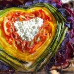 Tressa Dale / Peninsula Clarion
Feta and Parmesan cheese, cherry tomatoes, carrot, yellow bell pepper, asparagus, purple potatoes, beets and white button mushrooms form into a rainbow with a cheesy heart on focaccia bread.