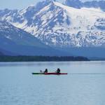 Kayakers paddle across Kenai Lake on Saturday, June 12, 2021, near Seward, Alaska. (Photo by Michael Armstrong/Homer News)