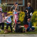 Children wait in anticipation for the 2021 Homer Fourth of July Parade to begin. As cars would drive by the crowd, the kids would chant honk, honk, honk and cheer when the passersby would comply. (Photo by Sarah Knapp/Homer News)