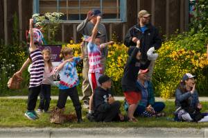 Children wait in anticipation for the 2021 Homer Fourth of July Parade to begin. As cars would drive by the crowd, the kids would chant honk, honk, honk and cheer when the passersby would comply. (Photo by Sarah Knapp/Homer News)