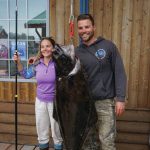 Lisa Stengel of Fort Lauderdale, Florida, poses for a photo with Capt. Brian Reid of the Castle Cape on Monday, July 12, 2021, at Coal Point Seafoods in Homer, Alaska, with a 71.4-pound halibut that she caught with a pole spear while free diving in Kachemak Bay. Stengel and her party went on a spearfishing expedition with Reid of Coldwater AK. (Photo by Michael Armstrong/Homer News)