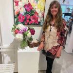 Gerri Martin poses with her show, "Peonies: Alaska's Floral Gems," for First Friday, July 2, 2021, at Fireweed Gallery in Homer, Alaska. (Photo courtesy of Gerri Martin)