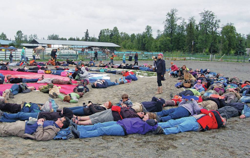 Photo courtesy of Mavis Muller 
Mavis Muller, center, with bull horn, arranged 2011 Salmonfest attendees for an aerial art event in the rodeo arena at Kenai Peninsula Fairgrounds near Ninilchik, Alaska.