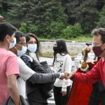 Tyler Hickman, senior vice president of Icy Strait Point, greets members of the Nambiar family from Fort Lauderdale, Florida, the first visitors to Hoonah to come off a cruise ship in over a year. Alaska Native singers and dancers met passengers as they disembarked. (Peter Segall / Juneau Empire)