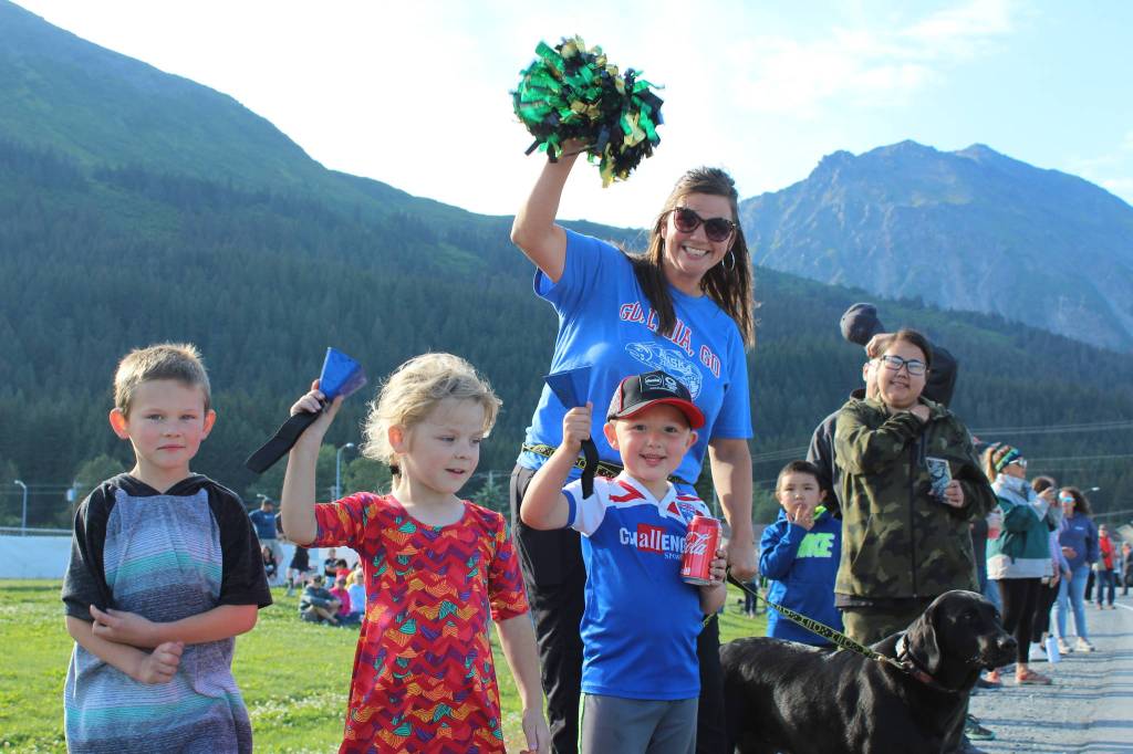 Rebekah Ivy (pom-pom) cheers on Olympic gold medalist Lydia Jacoby during a parade in Seward with Tell (left), Hazel (second from left) and Tell (right).