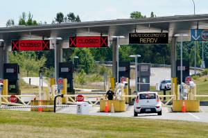 FILE - In this June 8, 2021, file photo, a car approaches one of the few lanes open at the Peace Arch border crossing into the U.S. in Blaine, Wash. Canada is lifting its prohibition Monday, Aug. 9 on Americans crossing the border to shop, vacation or visit, but the United States is keeping similar restrictions in place for Canadians. The reopening is part of a bumpy return to normalcy from COVID-19 travel bans.  (AP Photo/Elaine Thompson, File)