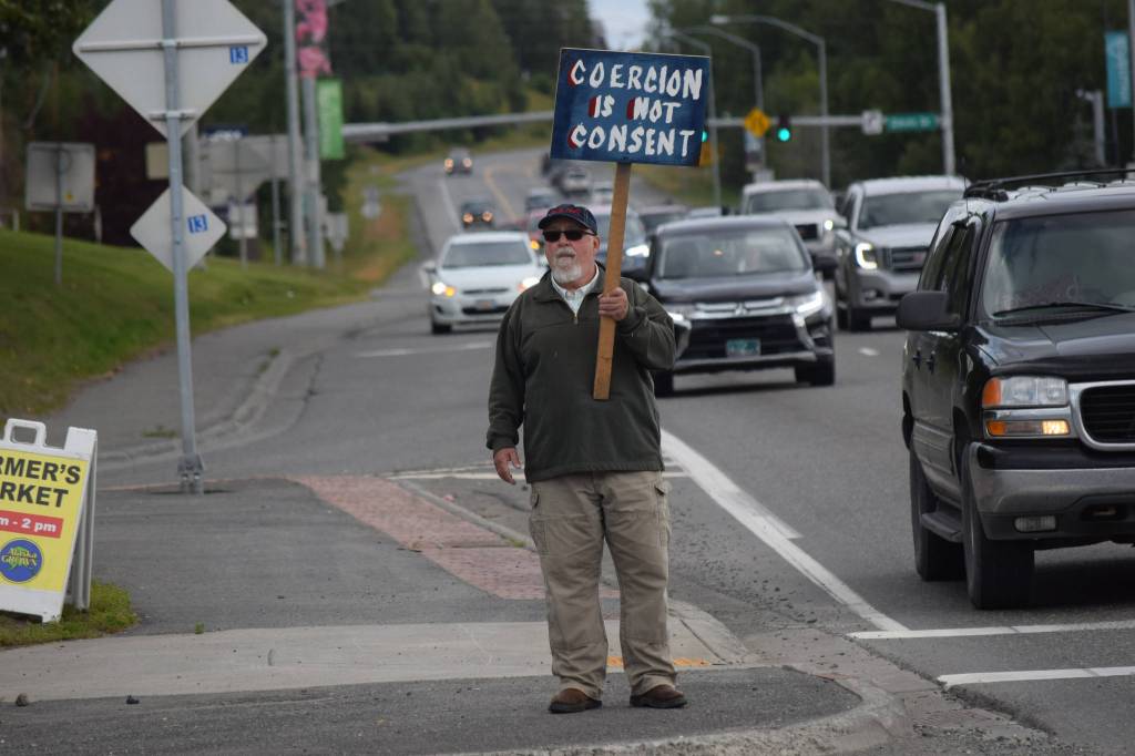 Kevin Hall stands at the Y intersection of the Kenai Spur and Sterling highways in Soldotna on Saturday, Aug. 14 to protest mandatory COVID-19 vaccines and mitigation protocols. (Camille Botello/Peninsula Clarion)