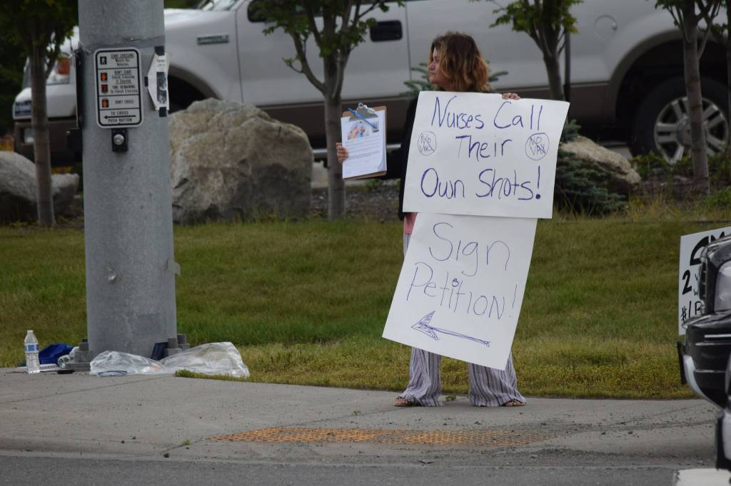 A demonstrator stands at the Y intersection of the Kenai Spur and Sterling highways in Soldotna on Saturday, Aug. 14 to protest mandatory COVID-19 vaccines and mitigation protocols. (Camille Botello/Peninsula Clarion)
