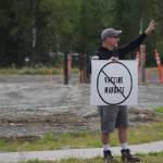 A demonstrator stands at the Y intersection of the Kenai Spur and Sterling highways in Soldotna on Saturday, Aug. 14 to protest mandatory COVID-19 vaccines and mitigation protocols. (Camille Botello/Peninsula Clarion)