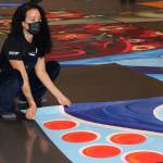 Dana Zigmund / Capital City Weekly
Tlingit and Athabascan artist, designer and activist Crystal Kaakeeyaa Worl places a portion of what will become the 60-by 20-foot public mural depicting Elizabeth Kaaxgal.aat Peratrovich, a Tlingit civil rights icon, into place at Centennial Hall on Aug. 13. Once complete, the mural will appear on the currently blank south wall of the Marine Parking garage, the structure on which the downtown branch of Juneaus public library sits.