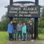 Sarah, Michael, Pete, Becky, Will and Margaret take a family picture in front of the Homer welcome sign on Baycrest.