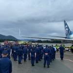 Coast Guardsmen stand in formation at Juneau International Airport as the body of Chief Petty Officer Jeffery DeRonde, who died over the weekend, is loaded on an airplane on Sept. 7, 2021. (Courtesy photo / Capital City Fire/Rescue)