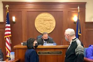 Senate Majority Leader Shelley Hughes, R-Palmer, right, speaks with Senate President Peter Micciche, R-Soldotna, and Sen. Bert Stedman, R-Sitka, during a floor debate in the Alaska Senate over vaccine mandates on Friday, Sept. 10, 2021. (Peter Segall / Juneau Empire)