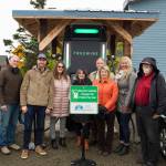 Community and state representatives responsible for bringing the fast-charging station to Homer pose for a photo in front of the station. (Photo by Sarah Knapp/Homer News)