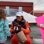 Amelia Conrad, 4, presents Zara Rutherford with a stuffed moose donning aviator goggles while Mclain Patterson, 7, holds a sign reading “Fly Zara Fly!” at Ward Air. Rutherford is flying her way around the world in pursuit of the Guinness world record for youngest woman solo pilot to circumnavigate the world. (Ben Hohenstatt / Juneau Empire)