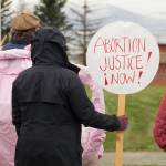 A woman holds a sign demanding abortion rights for women. (Photo by Sarah Knapp/Homer News)