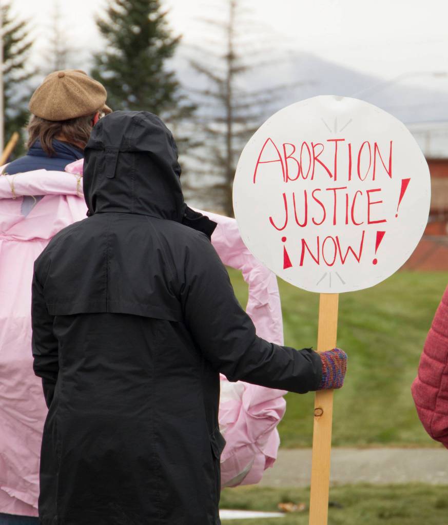 A woman holds a sign demanding abortion rights for women. (Photo by Sarah Knapp/Homer News)