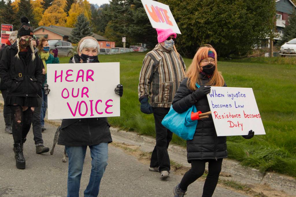 Demonstrators are seen marching down Pioneer Avenue to WKFL Park holding signs demanding womens rights. (Photo by Sarah Knapp/Homer News)