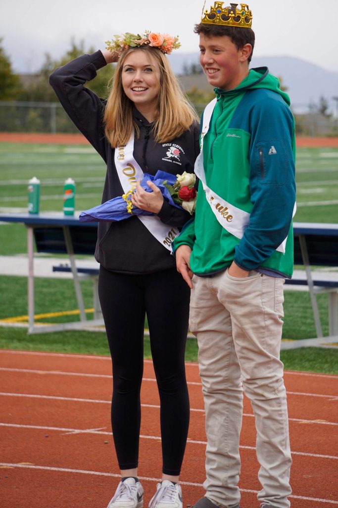 Sophomore class Duchess Minadora Reutov adjusts her crown as Duke Camden Wise watches at the Homer vs. Nikiski junior varsity football game on Saturday, Oct. 2, 2021, at Homer High School. (Photo by Michael Armstrong/Homer News)