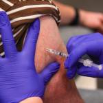 Michael S. Lockett / Juneau Empire
A Juneau resident receives a flu shot while getting a booster shot for the Pfizer coronavirus vaccine at Centennial Hall on Oct. 2, 2021. More than 1,300 Juneau residents received booster shots at the clinic, and about half of those people also received a flu shot.