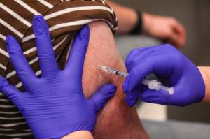 Michael S. Lockett / Juneau Empire
A Juneau resident receives a flu shot while getting a booster shot for the Pfizer coronavirus vaccine at Centennial Hall on Oct. 2, 2021. More than 1,300 Juneau residents received booster shots at the clinic, and about half of those people also received a flu shot.