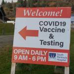 A sign points to the South Peninsula Hospital COVID-19 testing and vaccination clinic on Bartlett Street on Monday, Oct. 24, 2021, in Homer, Alaska. (Photo by Michael Armstrong/Homer News)