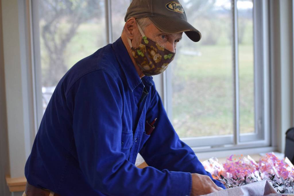 Charles Maier fills goodie bags at the Kenai Senior Center on Friday, Oct. 22, 2021 for next weekends drive-through trick-or-treat event. (Camille Botello/Peninsula Clarion)