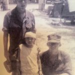 Cpl. Gary Squires kneels next to a young Vietnamese girl he helped rescue and the doctor who bandaged her wounds. (Photo provided by Gary Squires)