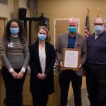 Derotha Ferraro, Dr. Christy Tuomi, Ryan Smith and Ken Castner pose for a photo with South Peninsula Hospitals mayoral recognition plaque. (Photo by Sarah Knapp/Homer News)