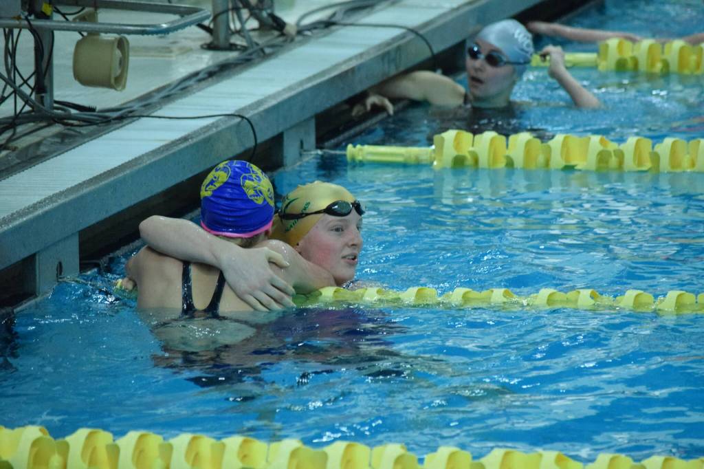 Sewards Lydia Jacoby hugs Jean Cook after she wins her race during the state swimming finals at Bartlett High School in Anchorage on Saturday, Nov. 6, 2021. (Camille Botello/Peninsula Clarion)
