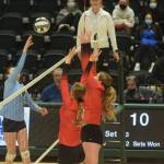 Valdez hitter Peyton Wade goes up for a kill against Kenai blockers Erin Koziczkowski and Emma Beck during the 3A state volleyball championship game at the Alaska Airlines Center in Anchorage on Saturday, Nov. 13, 2021. (Camille Botello/Peninsula Clarion)