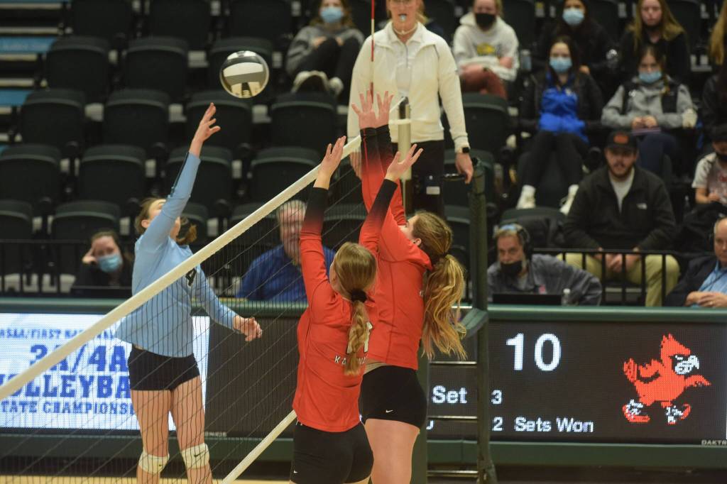 Valdez hitter Peyton Wade goes up for a kill against Kenai blockers Erin Koziczkowski and Emma Beck during the 3A state volleyball championship game at the Alaska Airlines Center in Anchorage on Saturday, Nov. 13, 2021. (Camille Botello/Peninsula Clarion)