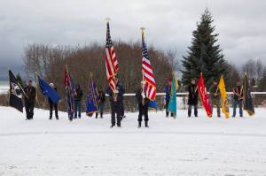 The color guard lowers the flags in honor of the veterans who have passed as Christie Hill plays Taps during the Veterans Day ceremony at the Alaska Islands and Ocean Visitor Center. (Photo by Sarah Knapp/Homer News)