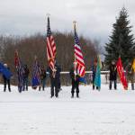 The color guard lowers the flags in honor of the veterans who have passed as Christie Hill plays Taps during the Veterans Day ceremony at the Alaska Islands and Ocean Visitor Center. (Photo by Sarah Knapp/Homer News)