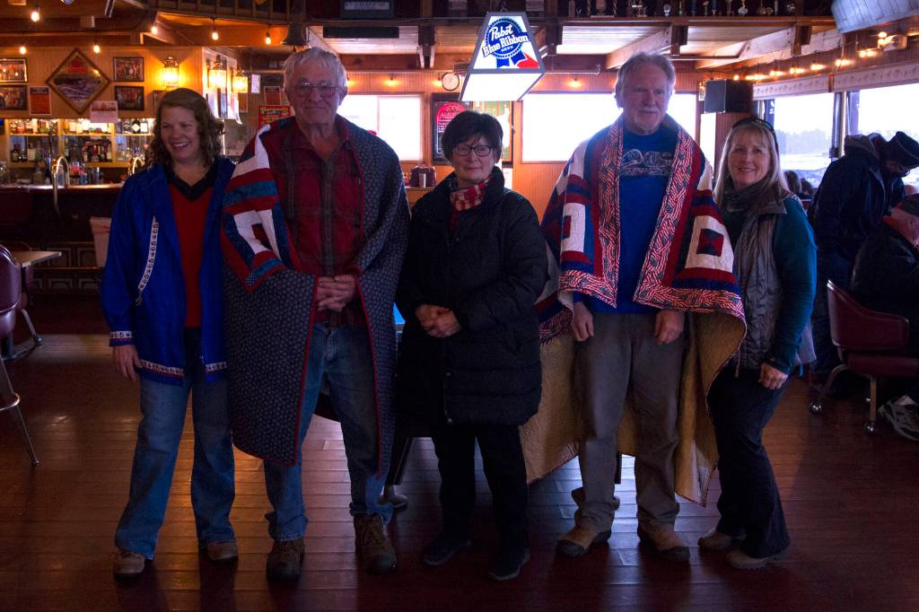 Quilts of Valor recipients Gary Squires (left) and Leroy Keene (right) are pictured after being covered in their quilts along with their family. (Photo by Sarah Knapp/Homer News)