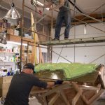 Matt (above) and Rob Wiard (below) lift the bench mold in order to rotate it for an additional layer of rubber to be poured on the clay. (Photo by Sarah Knapp/Homer News)