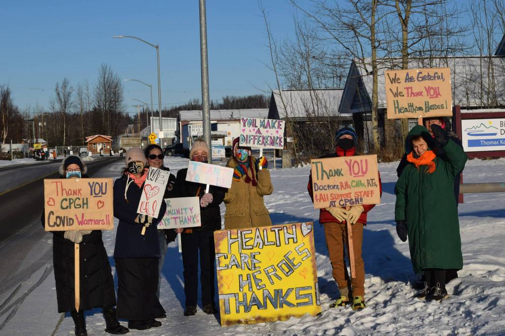 Members of the Many Voices advocacy group gather outside of Central Peninsula Hospital in Soldotna to demonstrate their support for healthcare staff on Saturday, Nov. 20, 2021. Folks protesting COVID-19 vaccine mandates and advocating for alternative treatments walk down the block behind them. (Camille Botello/Peninsula Clarion)